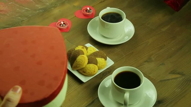 Young people in the cafe give each other gifts by candlelight.