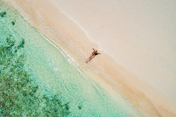 Fototapeta na wymiar Aerial drone aerial view of Beautiful girl having fun on the sunny tropical beach. Seychelles