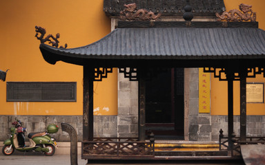 Detail of metal incence bowl decorated with dragons infront of a traditional building with a vintage style motorcycle in the old town of Suzhou city, China, Asia