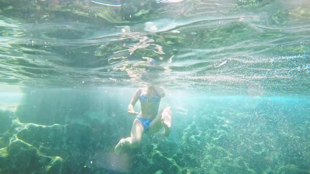 Young sexy girl in bikini swimsuit in the blue Lagoon at sea, underwater shot.