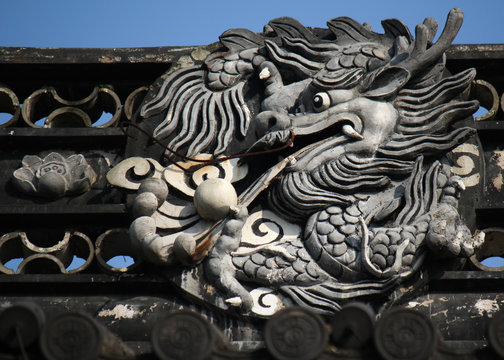 Dragon image on a roof top of a traditional Chinese building in an old town in China, Asia