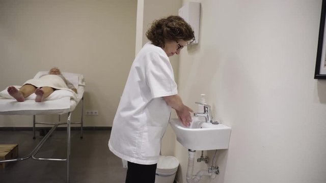 4K footage of acupuncturist washing his hands before a treatment in a private clinic