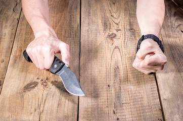 Large folding knife in hand. Hands and a knife.