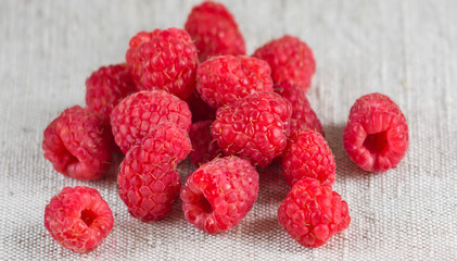 Macro of fresh ripe raspberries on the textile background in rustic style
