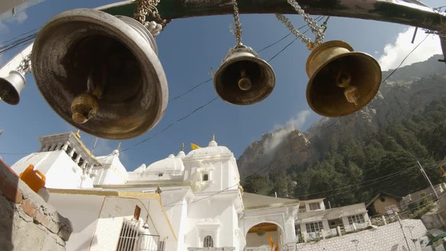 Bells on background mountains and main temple of Gangotri Himalayas 3600 metres blue sky