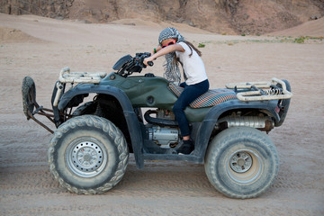 Fototapeta na wymiar Mädchen fährt Quad durch die Wüste