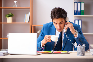 Young handsome businessman working in the office 