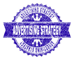 ADVERTISING STRATEGY rosette seal imprint with distress texture. Designed with round rosette, ribbon and small crowns. Blue vector rubber watermark of ADVERTISING STRATEGY tag with unclean texture.