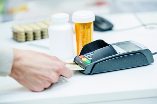 Customer paying in pharmacy - Powered by Adobe