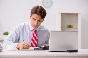 Young attractive businessman working in the office  