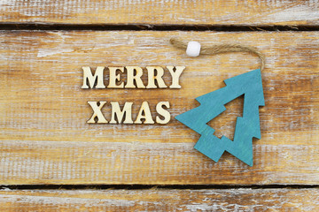 Merry Christmas written with wooden letters and wooden Christmas tree
