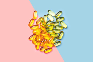 Fish oil capsules from above on pink and blue