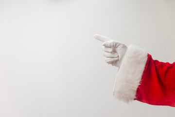 Santa Claus pointing finger. Direct approval guide trend. Closeup view of father xmas gloved hand in red costume show gesturing on white space background.
