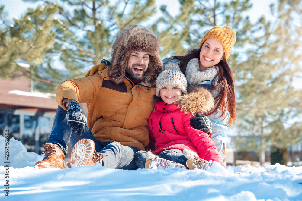 Wall mural winter vacation. family time together outdoors sitting hugging smiling happy close-up