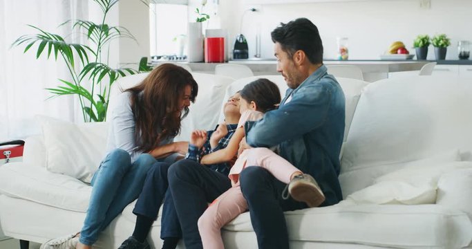 Portrait of happy family having fun in living room in slow motion.