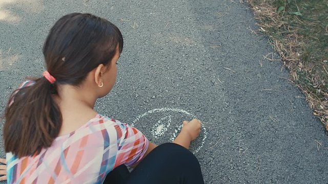 Top view of a little girl lying on picknick blanket blowing bubblegum candy bubbles, slow motion, 4k
