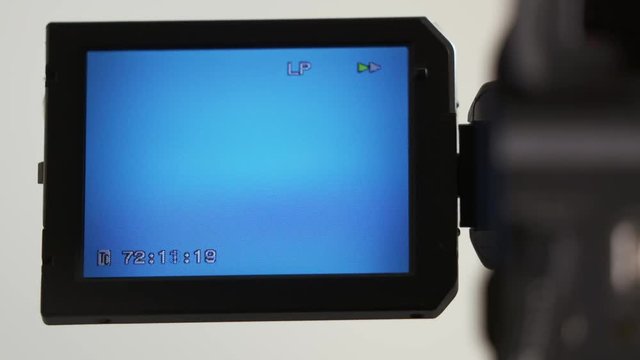 Indicators on LCD screen of digital camcorder while rewinding mini DV cassette tape