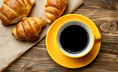 mug of coffee, croissants on wooden background