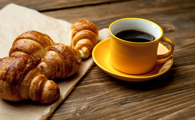 mug of coffee, croissants on wooden background