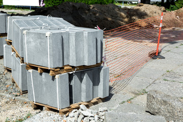 A new curb piled on pallets and ready for installation after repairing the walkway pavement