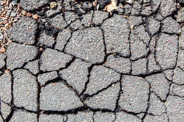 damaged pavement close-up of asphalt in cracks top view.