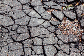 Corroded asphalt close up road surface cracks texture.