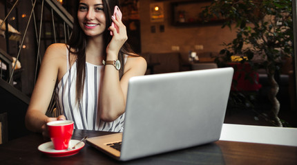 Young pretty caucasian woman in cafe in city centre with tablet laptop