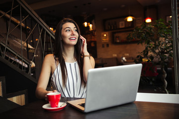 Young pretty caucasian woman in cafe in city centre with tablet laptop
