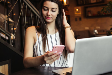 Young pretty caucasian woman in cafe in city centre with tablet laptop
