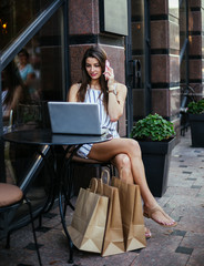 Young pretty woman in street cafe with tablet laptop