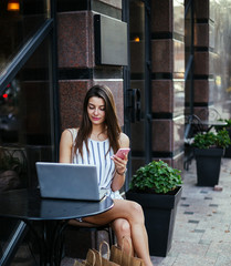 Young pretty woman in street cafe with tablet laptop