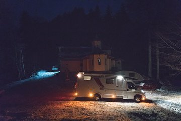 Night camping wtih camper van caravan in holiday outdoor adventure trip on the mountain. Nomad...