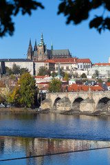 Colorful autumn Prague gothic Castle and Charles Bridge with the Lesser Town in the sunny Day, Czech Republic