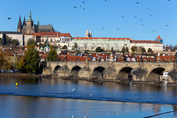 Colorful autumn Prague gothic Castle and Charles Bridge with the Lesser Town in the sunny Day, Czech Republic