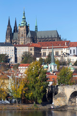 Fototapeta premium Colorful autumn Prague gothic Castle and Charles Bridge with the Lesser Town in the sunny Day, Czech Republic