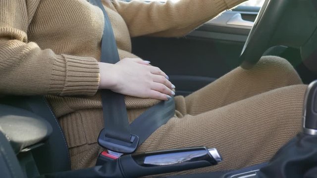 pregnant woman driver behind wheel, caring future mother wearing seatbelt stroking belly with future baby sitting at cabin auto behind steering
