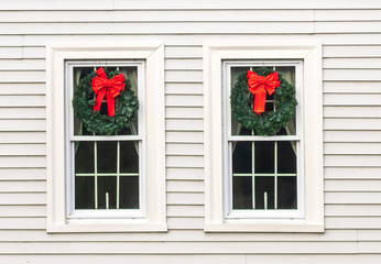 Wreaths hung on the windows of a white house