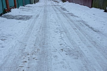 Obraz premium part of the winter road with gray and white dirty snow