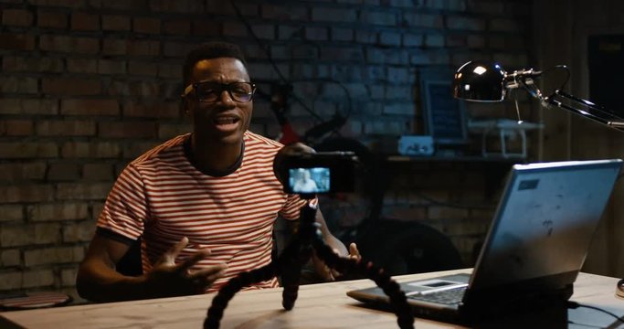 Slow motion shot of young African American man talking on camera in a garage