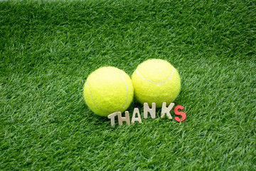 Tennis ball with Thank you on green grass