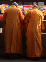 Two monks watching people in the temple yard from the balcony in the old town of Shanghai, China,...