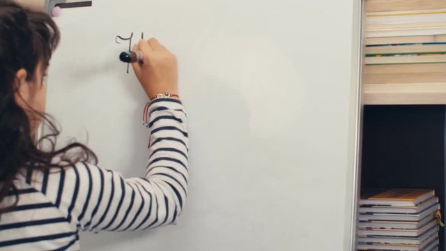 Girl writing homework on a white board at home, 4k