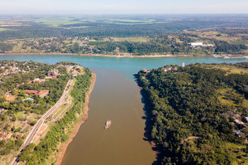 Triple Frontier, tri-border junction of Paraguay, Argentina and Brazil. Iguazú and Paraná rivers confluence. Aerial drone photo. Two color river - obrazy, fototapety, plakaty