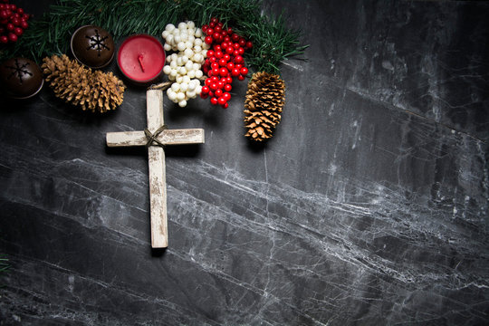 cross on black background with berries and pinecones