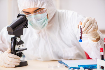 Young handsome lab assistant testing blood samples in hospital 