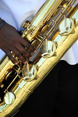 African american male jazz baritone saxophone musician performing outdoors.