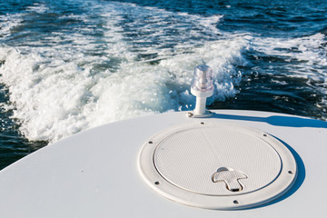 Back light on the stern of a boat with wake.