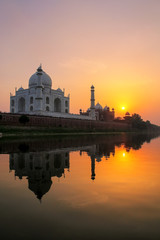 Obraz premium Taj Mahal reflected in Yamuna river at sunset in Agra, India