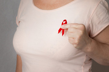 World AIDS day. A female with a red ribbon on a  T-shirt on a black background.