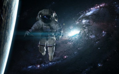 Astronaut and planet against a blue galaxy. Abstract science fiction. Elements of the image were furnished by NASA